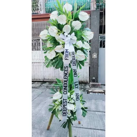 Product Description:

Express your deepest sympathies and honor the memory of a loved one with our Anthurium and Mums Funeral Arrangement. This elegant arrangement combines the vibrant, heart-shaped anthuriums with mums' soft, comforting presence, symbolizing both love and remembrance.

The anthuriums, with their bold red or white hues, convey heartfelt emotions and a lasting tribute, while the mums, traditionally associated with remembrance, add a gentle touch of peace and solace. Carefully arranged by our expert florists, this bouquet is designed to bring comfort and beauty to any funeral or memorial service.

Whether placed on a casket, used as a standing spray, or displayed as a centerpiece, the Anthurium and Mums Funeral Arrangement is a meaningful way to pay respect and offer condolences during difficult times.

Substitution Policy: To arrange and deliver your order at the time/day requested, the arrangement you ordered may require substitutions. We know that what you see is what you'd like to have delivered, so any substitutions made are equal or more in value and will be as similar to the requested arrangement as possible. Substitutions will be made, if necessary, for assorted flower arrangements and potted plants to provide the same colors as shown. This means that the type of flower or plant may change to something equal or greater in value. We will strive to maintain consistency in flower arrangements and potted plants of a single type, however, the color may be changed. Containers may also be substituted. Substitutions may also be made in the contents or containers of gourmet baskets, fruit trays, and other specialty gifts. Again, any replacements will be of equal or greater value and be similar.